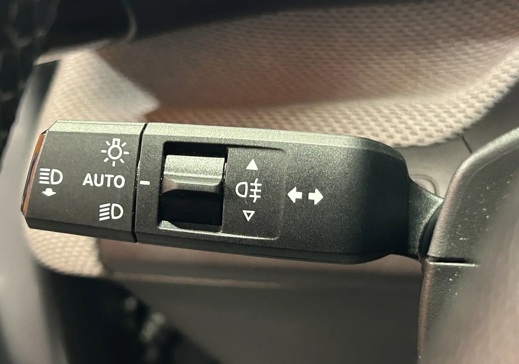 Gros plan sur la commande des phares et clignotants à gauche du volant dans l’habitacle gris d’une Citroën C3 2025.