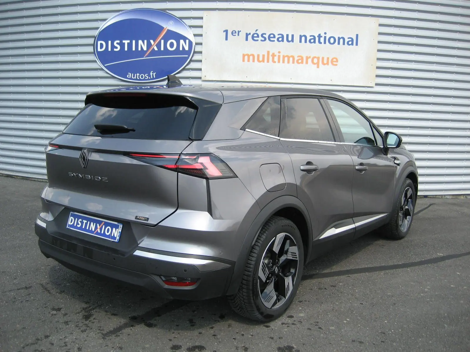 Vue 3/4 arrière droite d'une Renault SYMBIOZ gris cassiopée, avec feux arrière LED et jantes bi-ton distinctives.