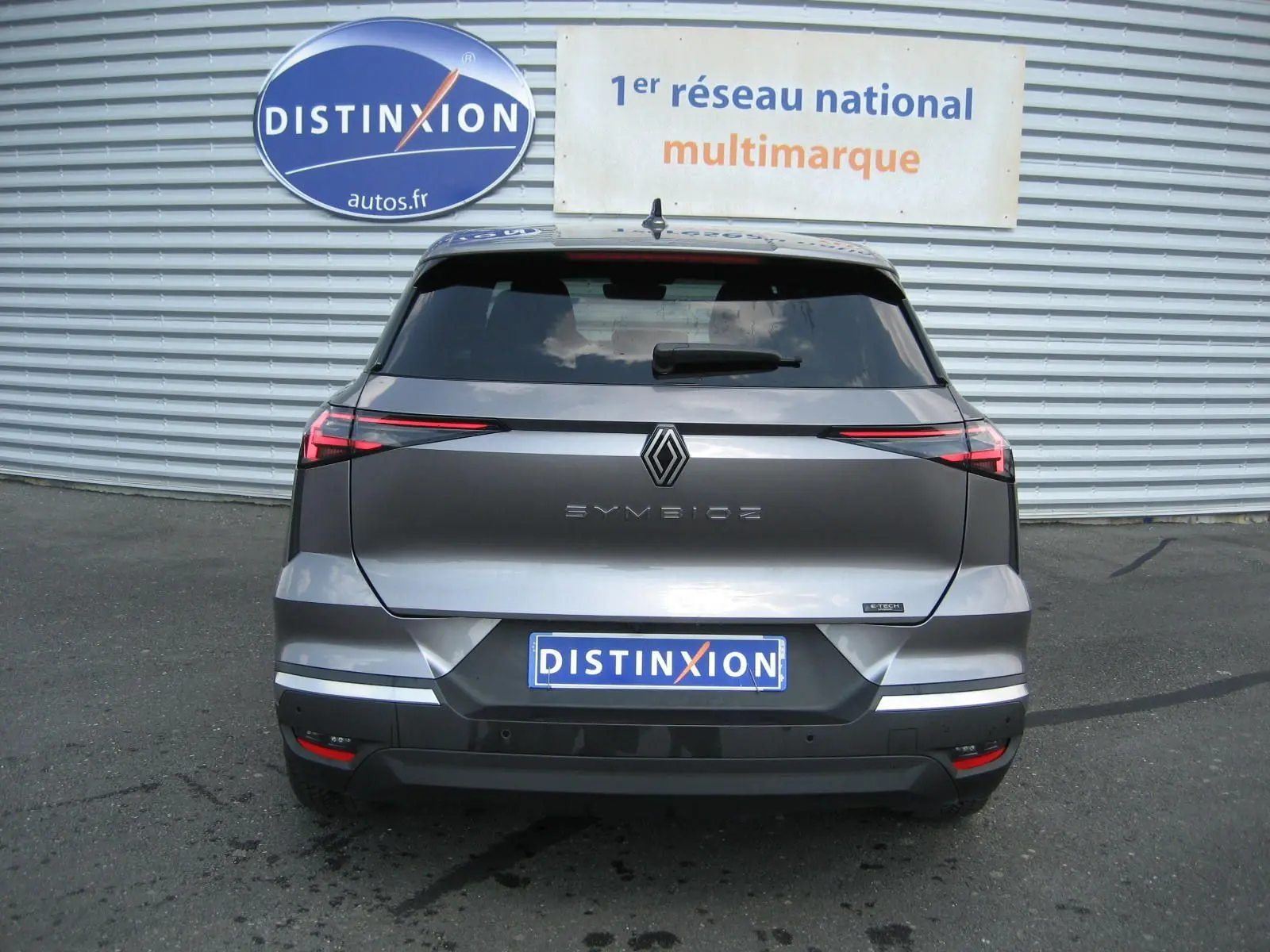 Vue arrière d'une Renault Symbioz gris cassiopée, avec feux arrière LED fins et logo central distinctif.