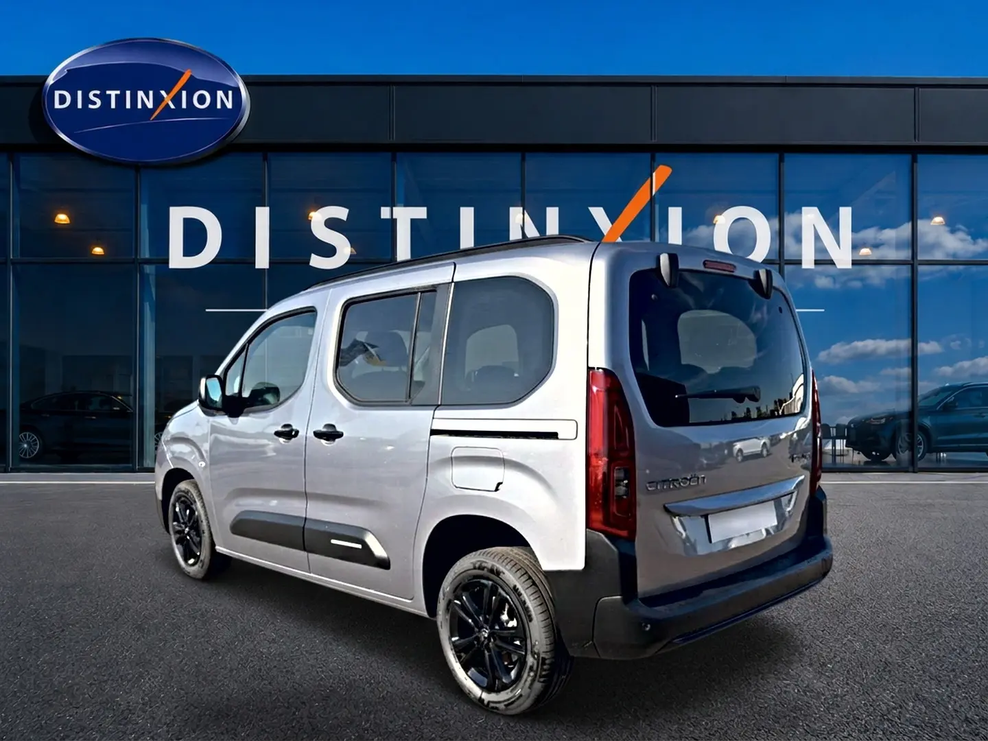 Vue 3/4 arrière droite du Citroën Berlingo Steel Grey 2026 avec jantes noires et barres de toit visibles.