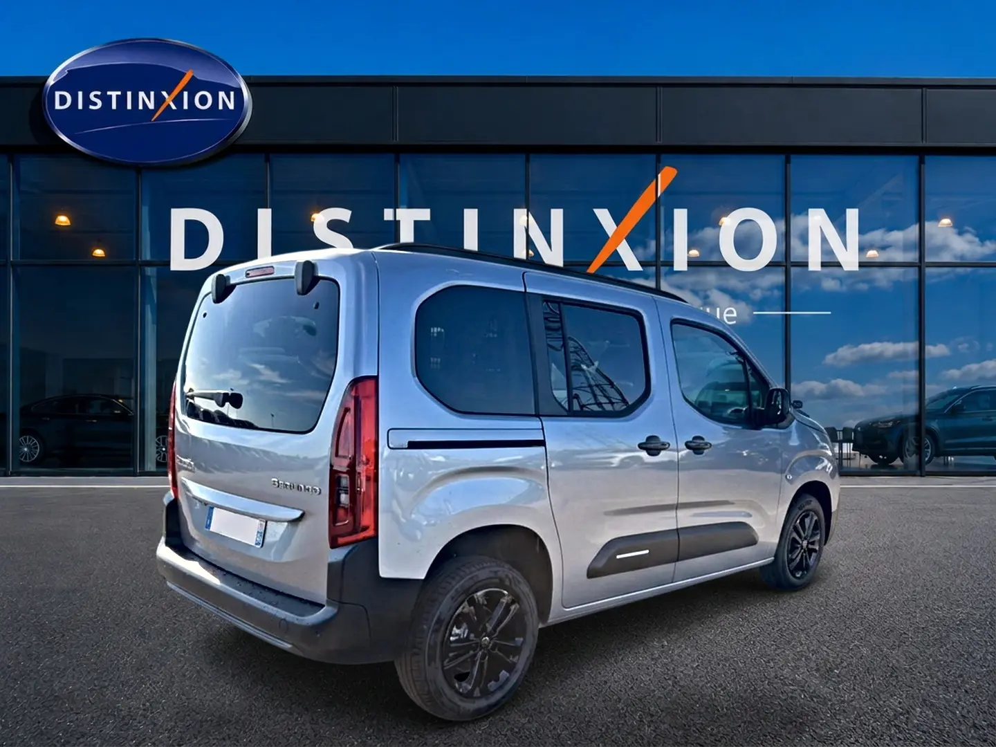 Vue 3/4 arrière droite d’un Citroën Berlingo Steel Grey 2026 avec portes latérales vitrées et jantes alu noires.