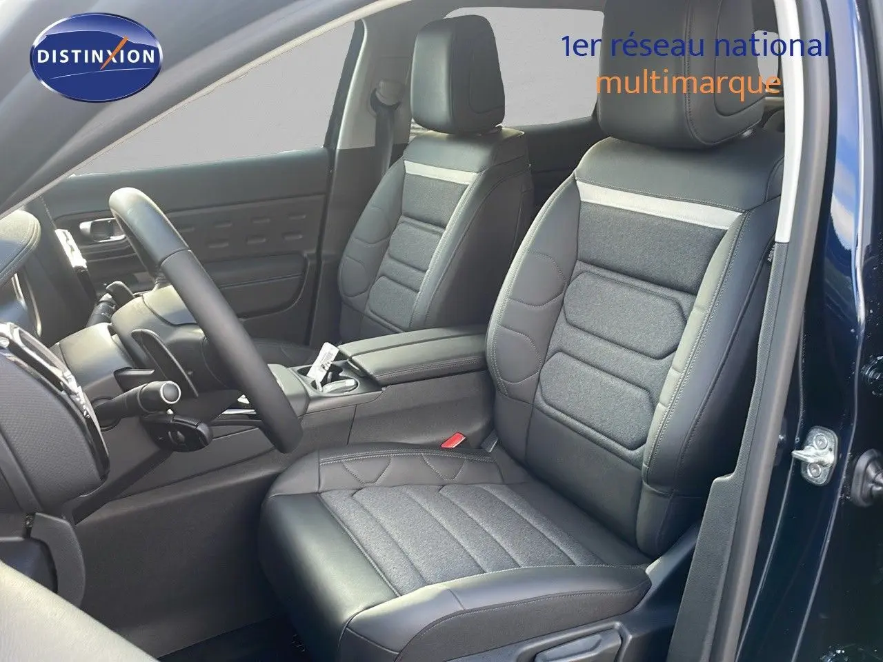 Intérieur avant du Citroën C5 Aircross bleu Eclipse Metal, sièges en cuir noir et tissu gris, volant visible côté gauche.