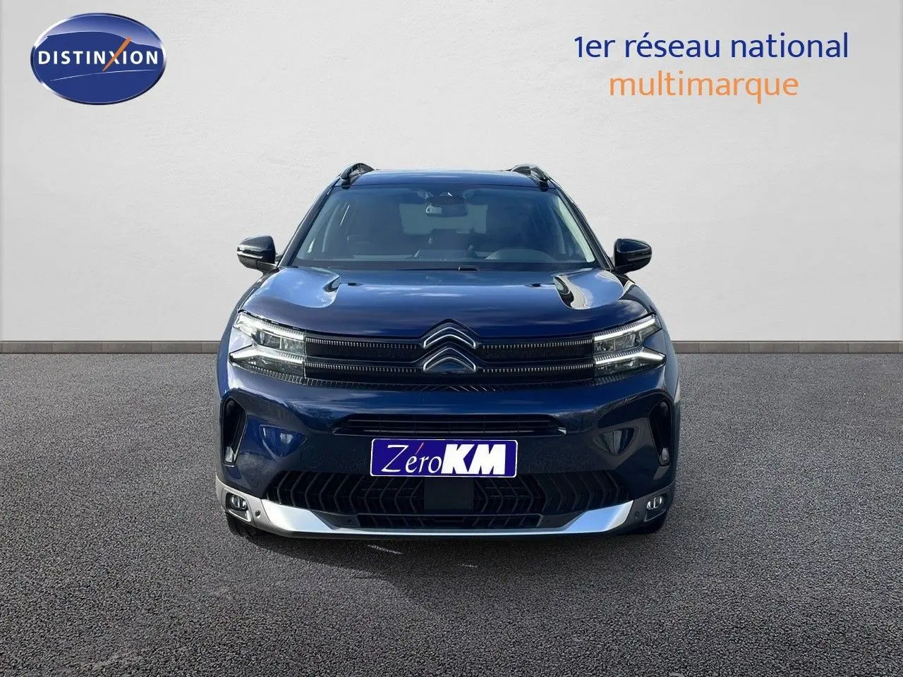 Vue frontale d'un Citroën C5 Aircross 2025 bleu Eclipse Metal avec calandre distinctive et feux LED allumés.