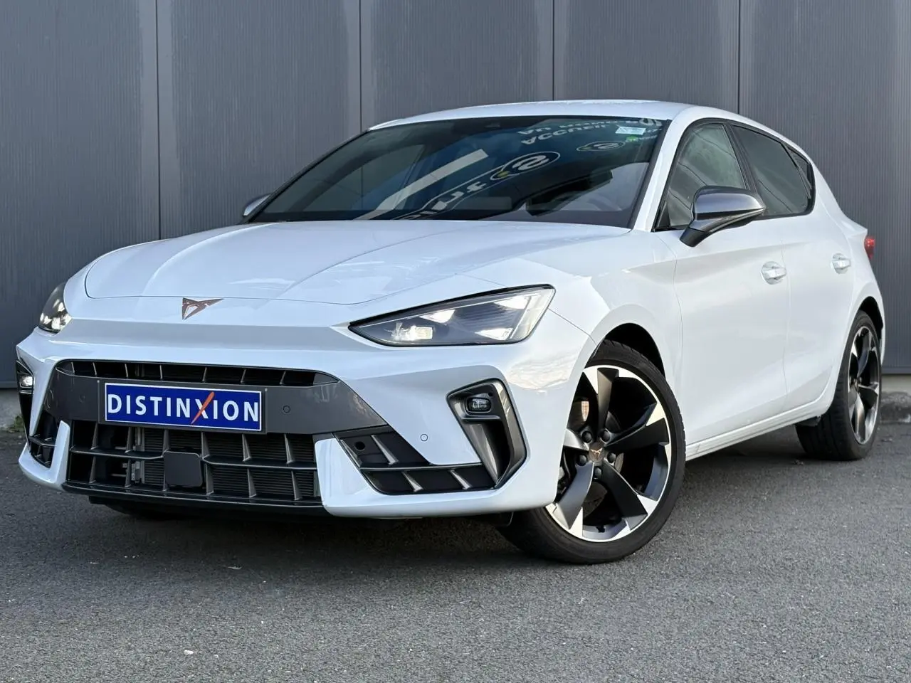 Vue 3/4 avant droite d'une CUPRA Leon blanc Neige avec jantes alliage 18'' et signature lumineuse Tri-LED.