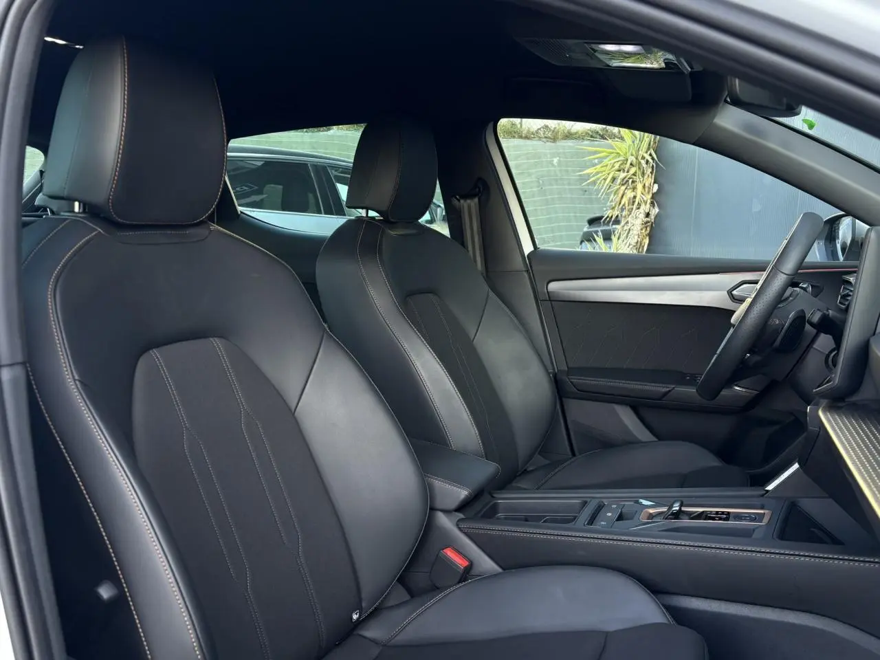 Vue intérieure côté droit montrant les sièges sports noirs et la console centrale de la CUPRA Leon 2025.