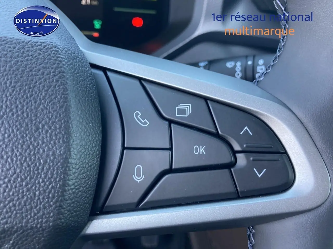 Gros plan sur les commandes multifonctions à droite du volant du Dacia Duster gris schiste, avec boutons de navigation et appel.