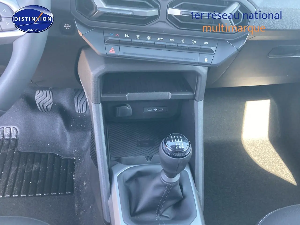 Vue rapprochée de la console centrale du Dacia Duster gris schiste 2026, avec levier de vitesse manuel et commandes clim.