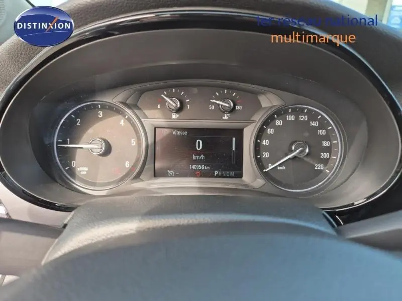 Vue rapprochée du tableau de bord et compteur digital de l'Opel Mokka X gris, affichant 140956 km.