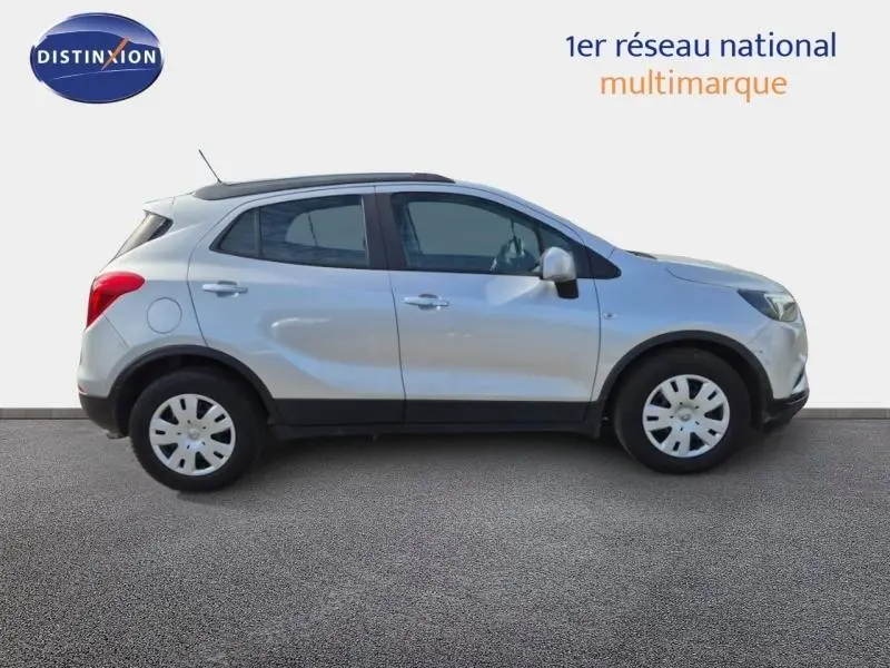 Vue de profil côté droit d'un Opel Mokka X gris minéral avec jantes acier et rétroviseurs argentés sur fond neutre.