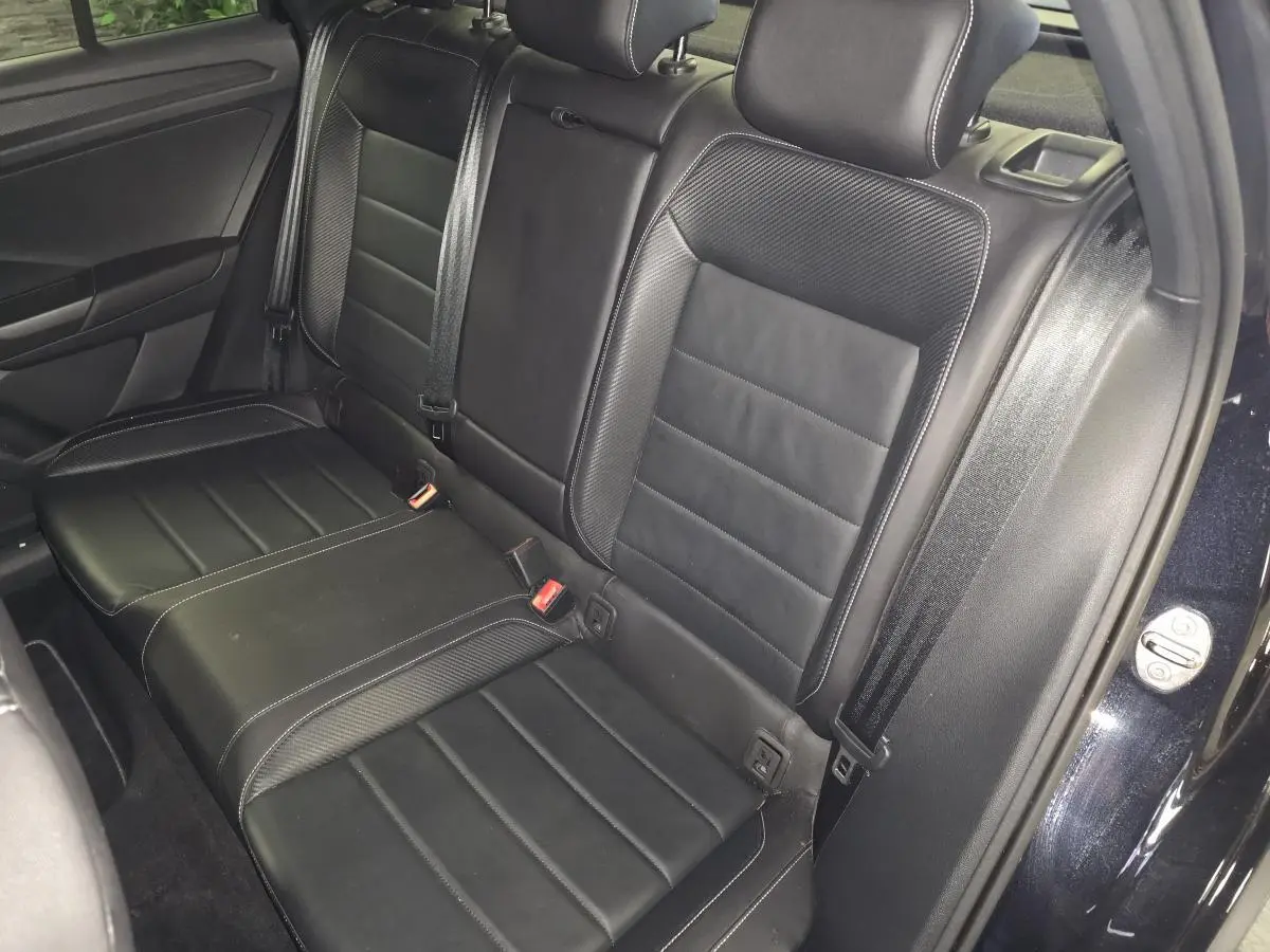 Vue intérieure de la banquette arrière en cuir noir du Volkswagen T-Roc R-Line 2023, côté droit avec ceinture de sécurité.