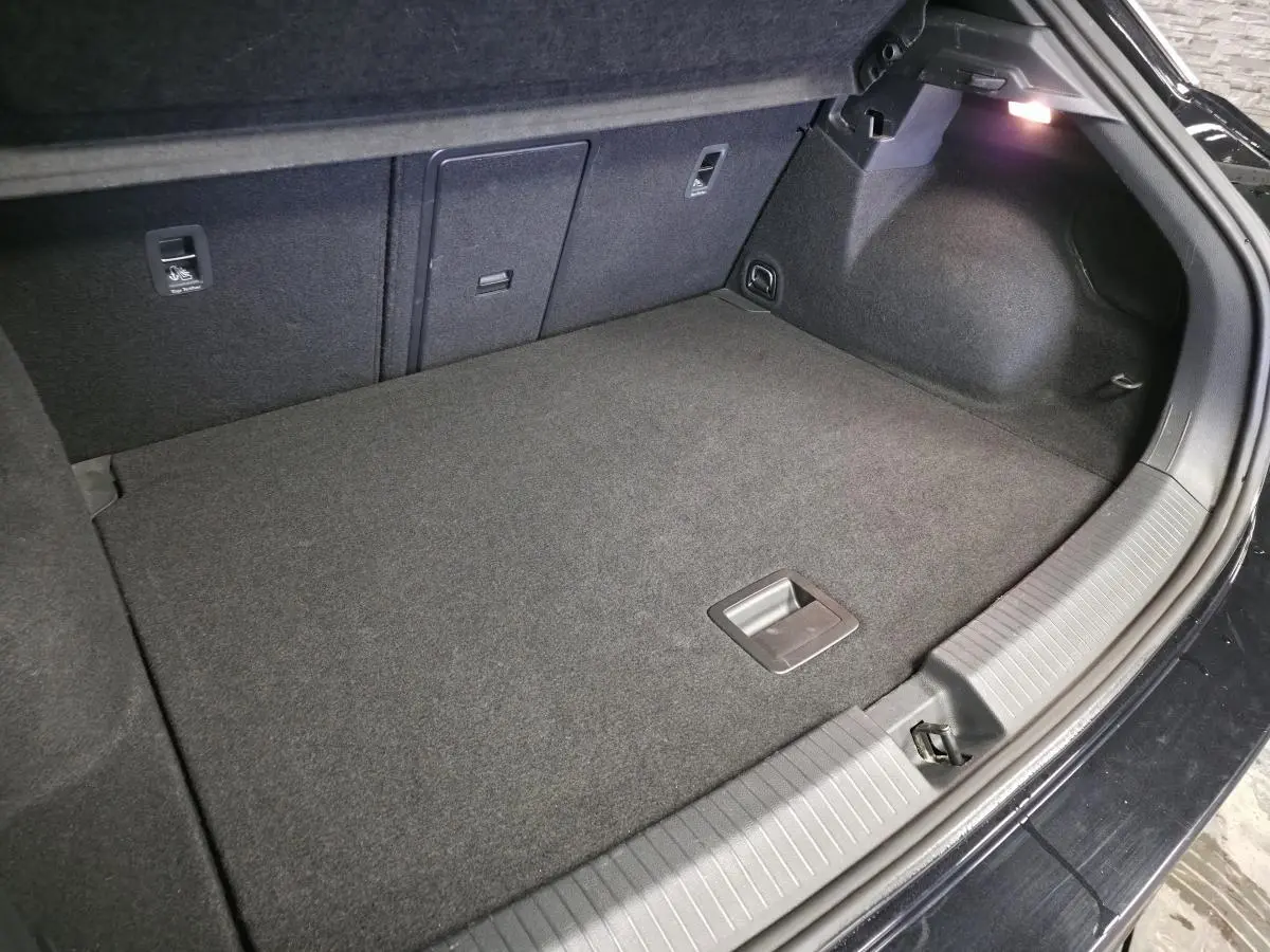 Coffre ouvert du Volkswagen T-Roc noir 2023, vue intérieure montrant un espace de rangement propre et bien fini.