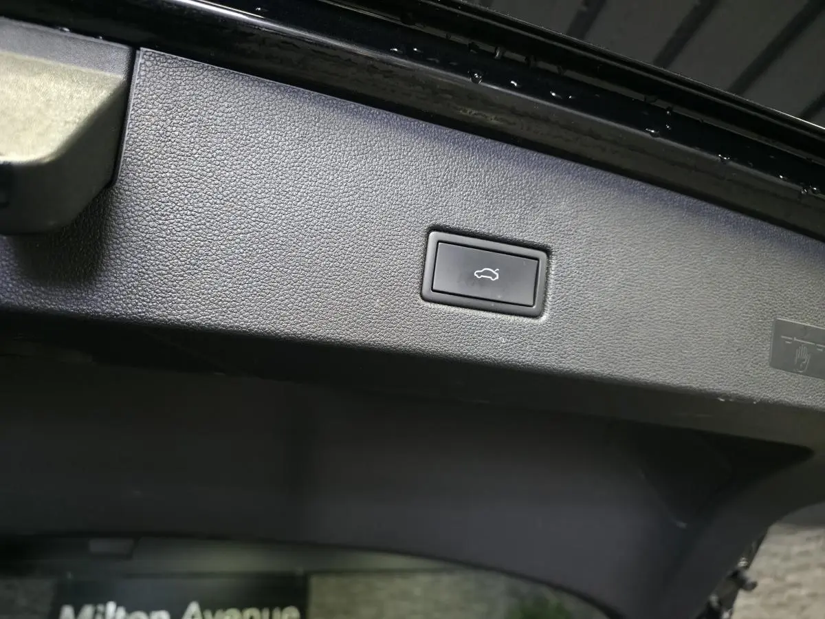 Bouton d'ouverture électrique du hayon sur la partie intérieure du coffre du Volkswagen T-Roc noir 2023.