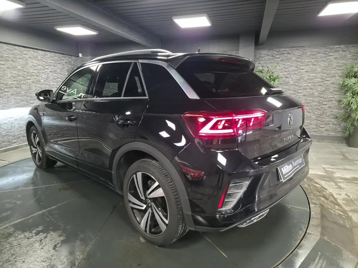 Volkswagen T-Roc noir en 3/4 arrière droit, avec feux LED allumés et jantes alliage Nevada 18 pouces.