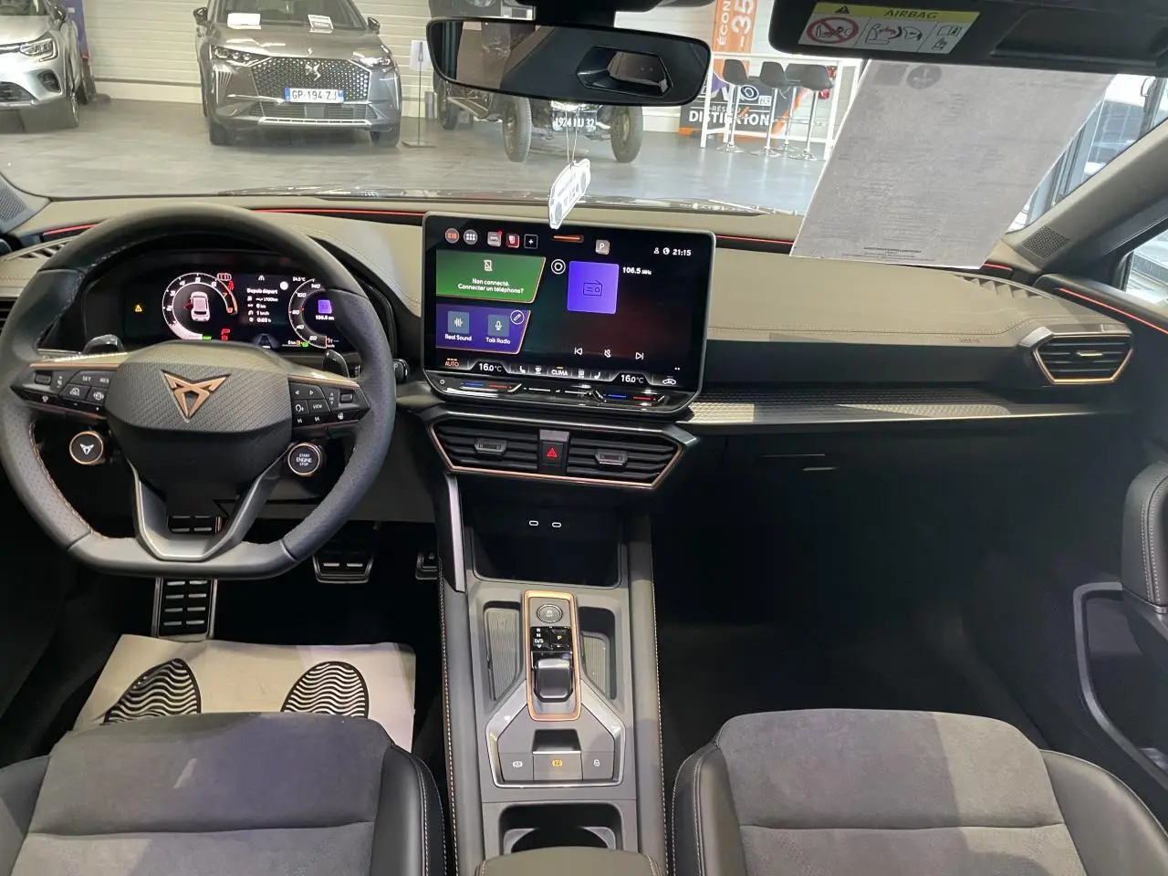 Vue intérieure avant de la CUPRA Leon 2026, tableau de bord noir avec écran tactile central et volant sport marqué Cupra.