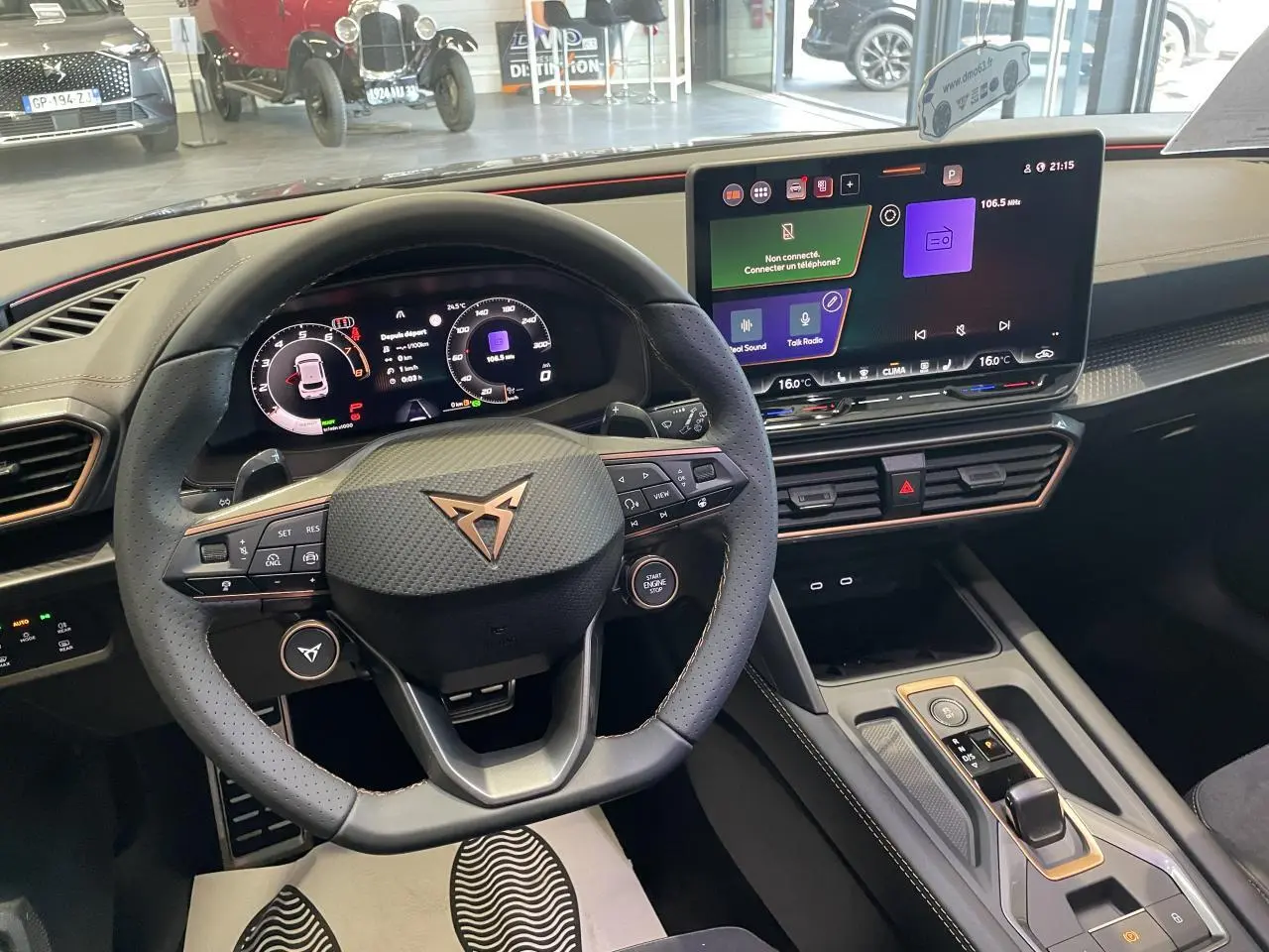 Vue intérieure du poste de conduite de la CUPRA Leon gris, avec volant sport et écran tactile HD 12,9 pouces.