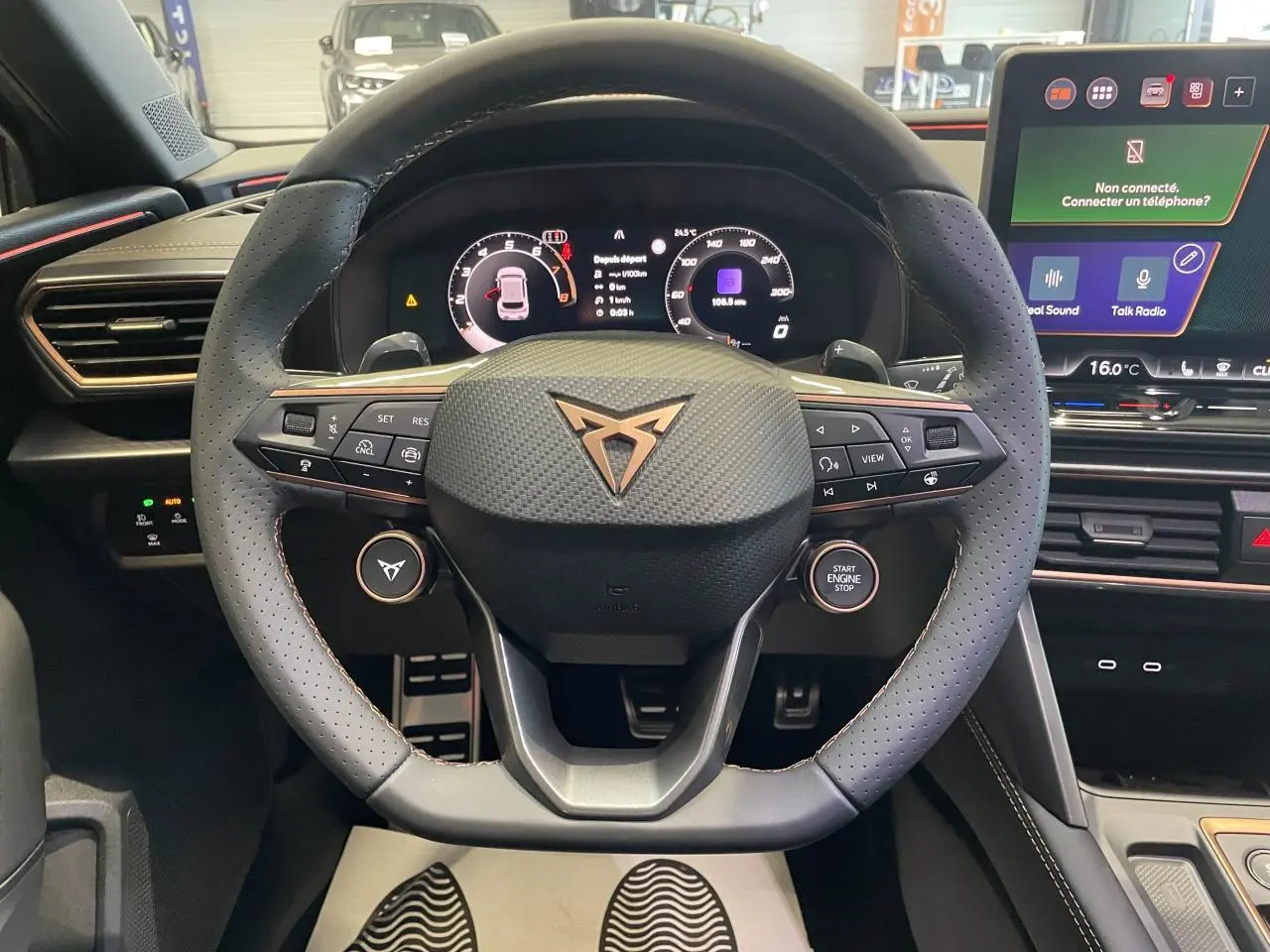 Volant perforé gris avec logo Cupra cuivré, tableau de bord digital et écran tactile dans l'habitacle du Cupra Leon 2026.