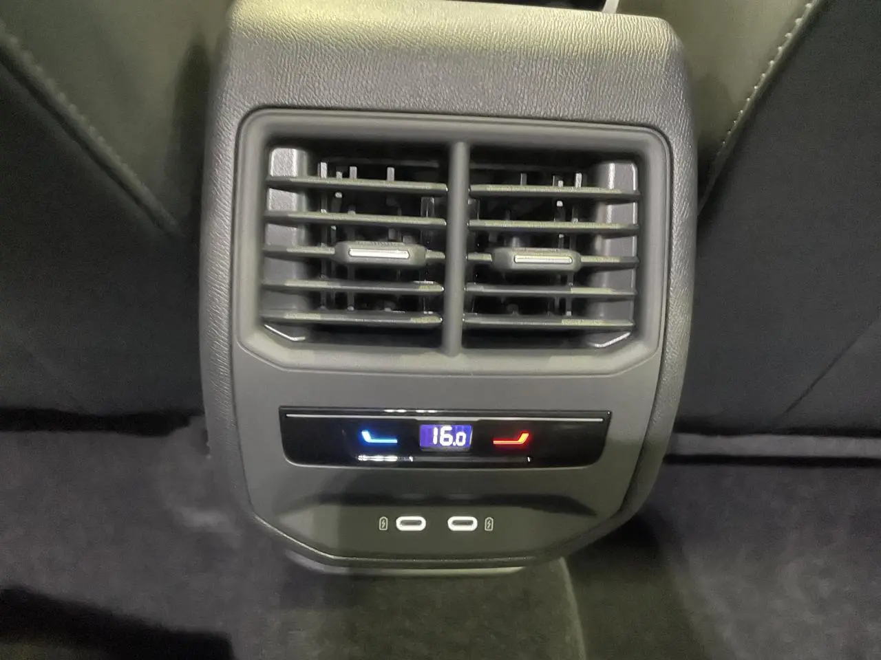 Gros plan sur la console arrière de la CUPRA Leon gris, avec bouches d’aération et commandes climatisation à 16°C.