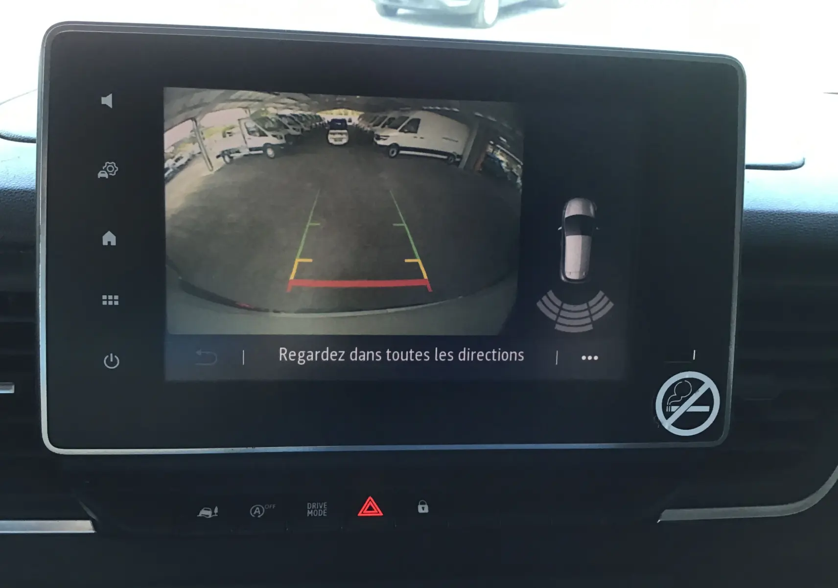 Écran tactile intérieur montrant la caméra de recul du Nissan Primastar blanc, avec lignes de guidage colorées et alertes visuelles.