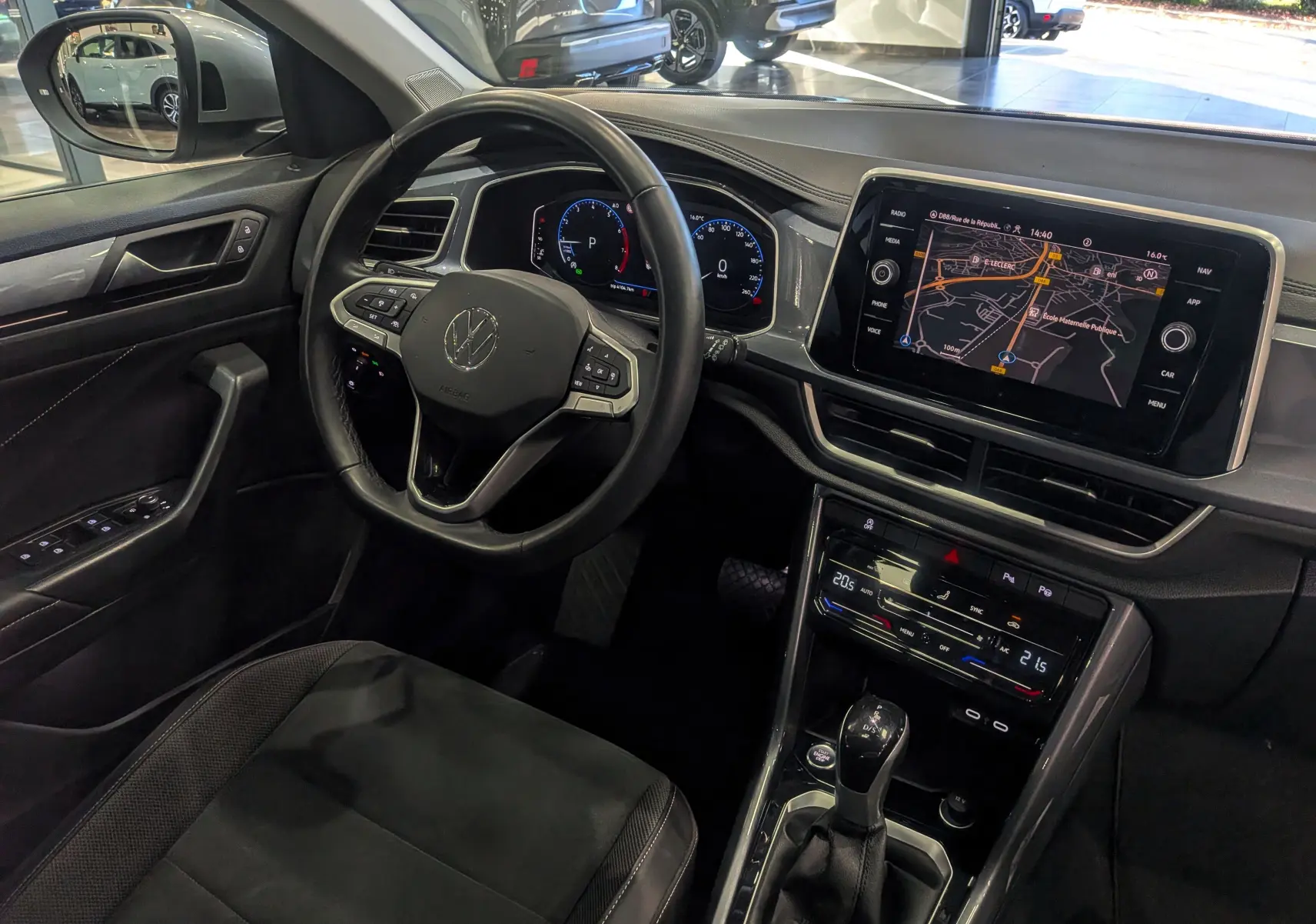 Vue intérieure côté conducteur du Volkswagen T-Roc 2024 avec tableau de bord numérique et écran tactile de navigation.