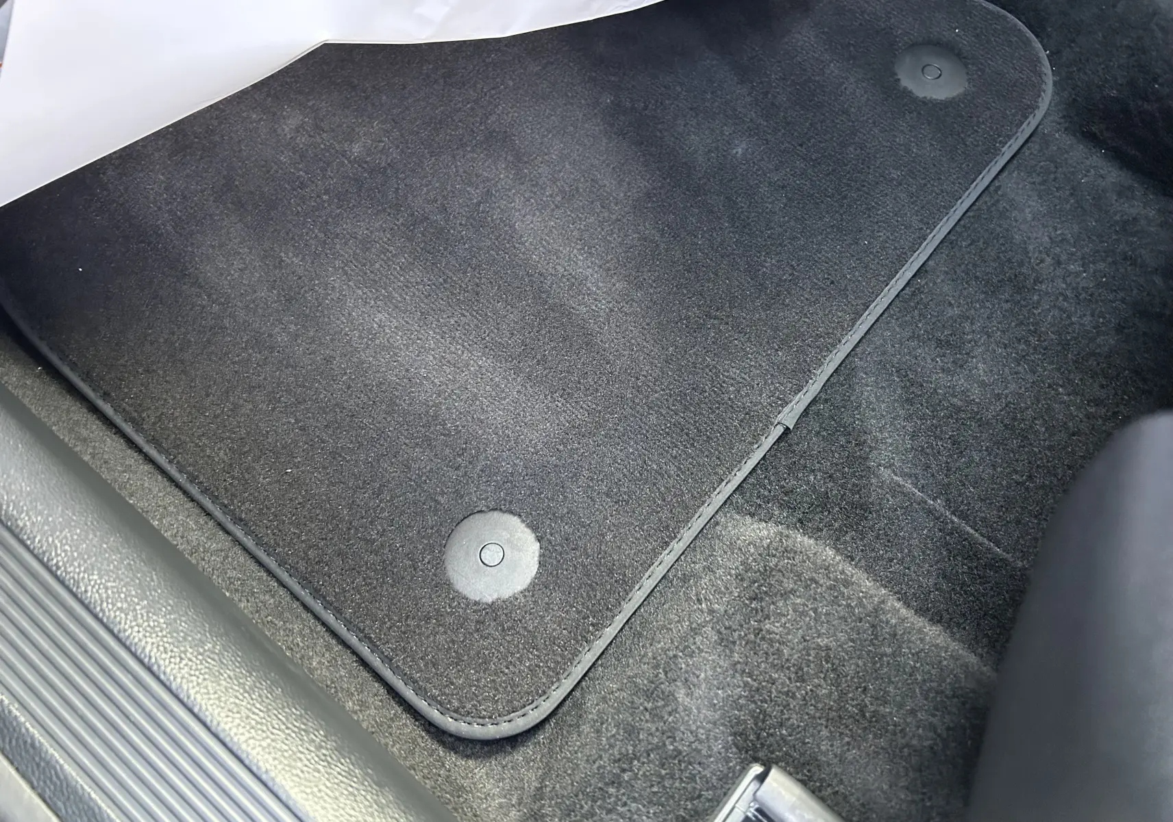 Détail du tapis de sol noir dans l'habitacle d'un Volkswagen T-Roc TSI 150 DSG Life 30 Years, vue côté passager.