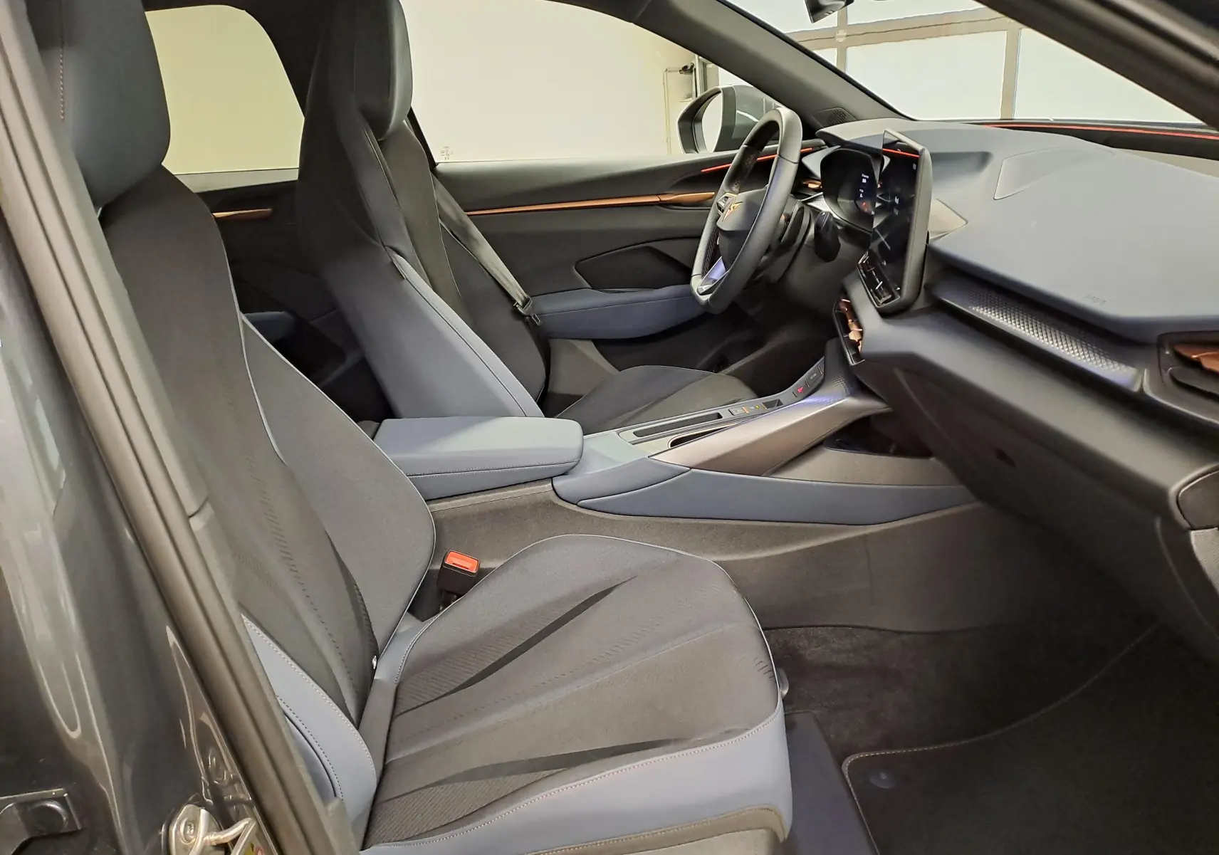 Vue intérieure côté conducteur de la CUPRA TERRAMAR 2025 avec sièges sport noirs et tableau de bord moderne.