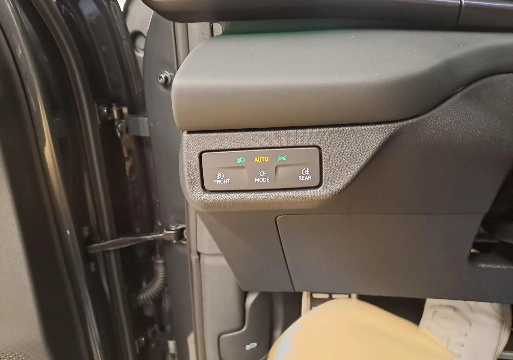 Gros plan sur les commandes d’éclairage côté gauche du tableau de bord d’un CUPRA TERRAMAR 2025 gris Timanfaya.