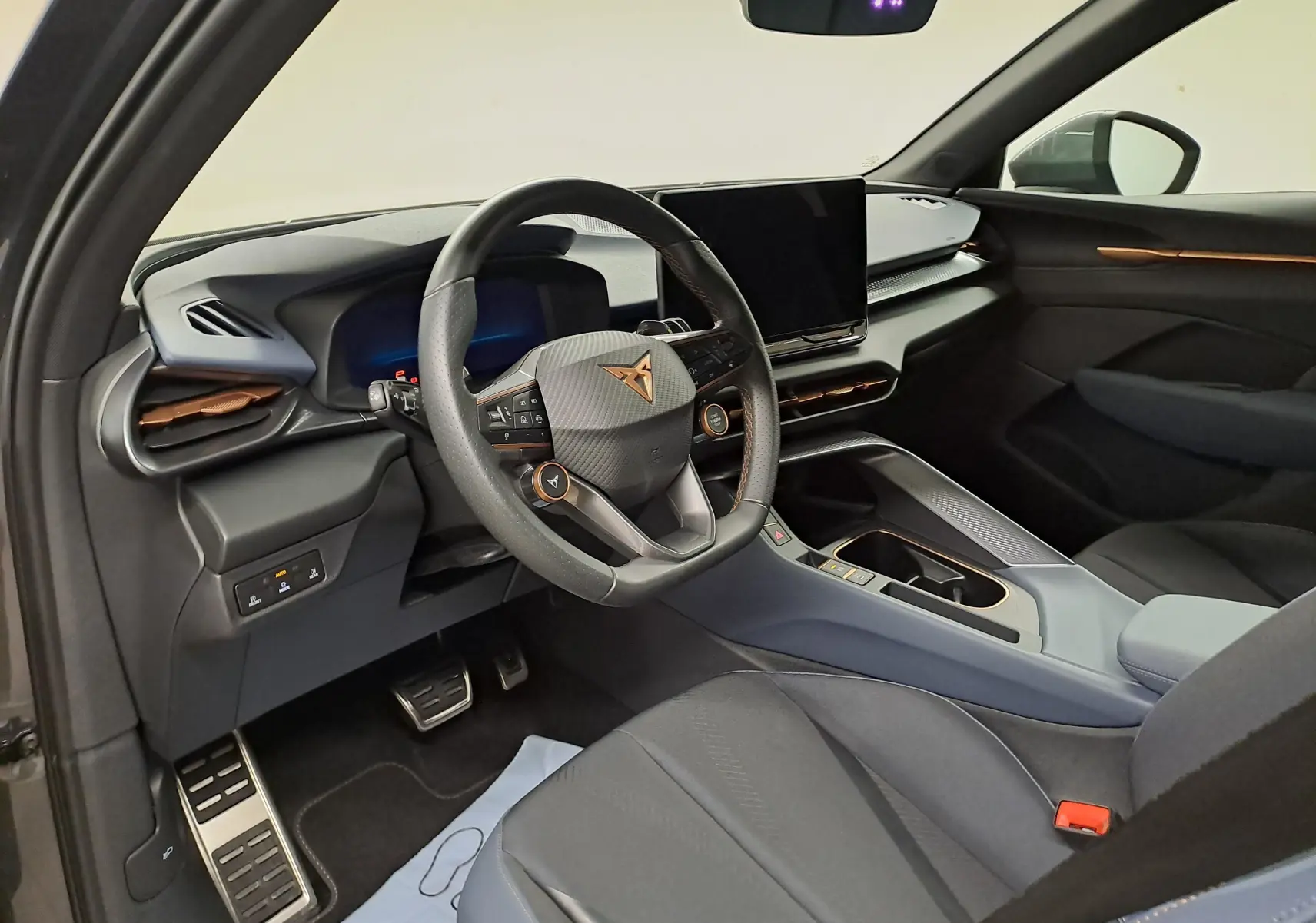 Vue intérieure côté conducteur du CUPRA TERRAMAR 1.5 eTSI 150 DSG7, avec tableau de bord moderne et finitions cuivrées.