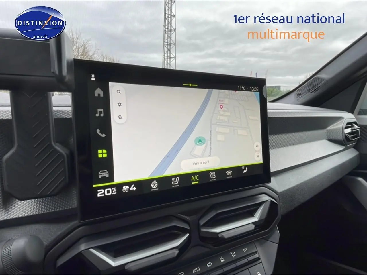 Vue intérieure du tableau de bord du Dacia Duster 2026 avec écran tactile GPS et aérateurs hexagonaux noirs.
