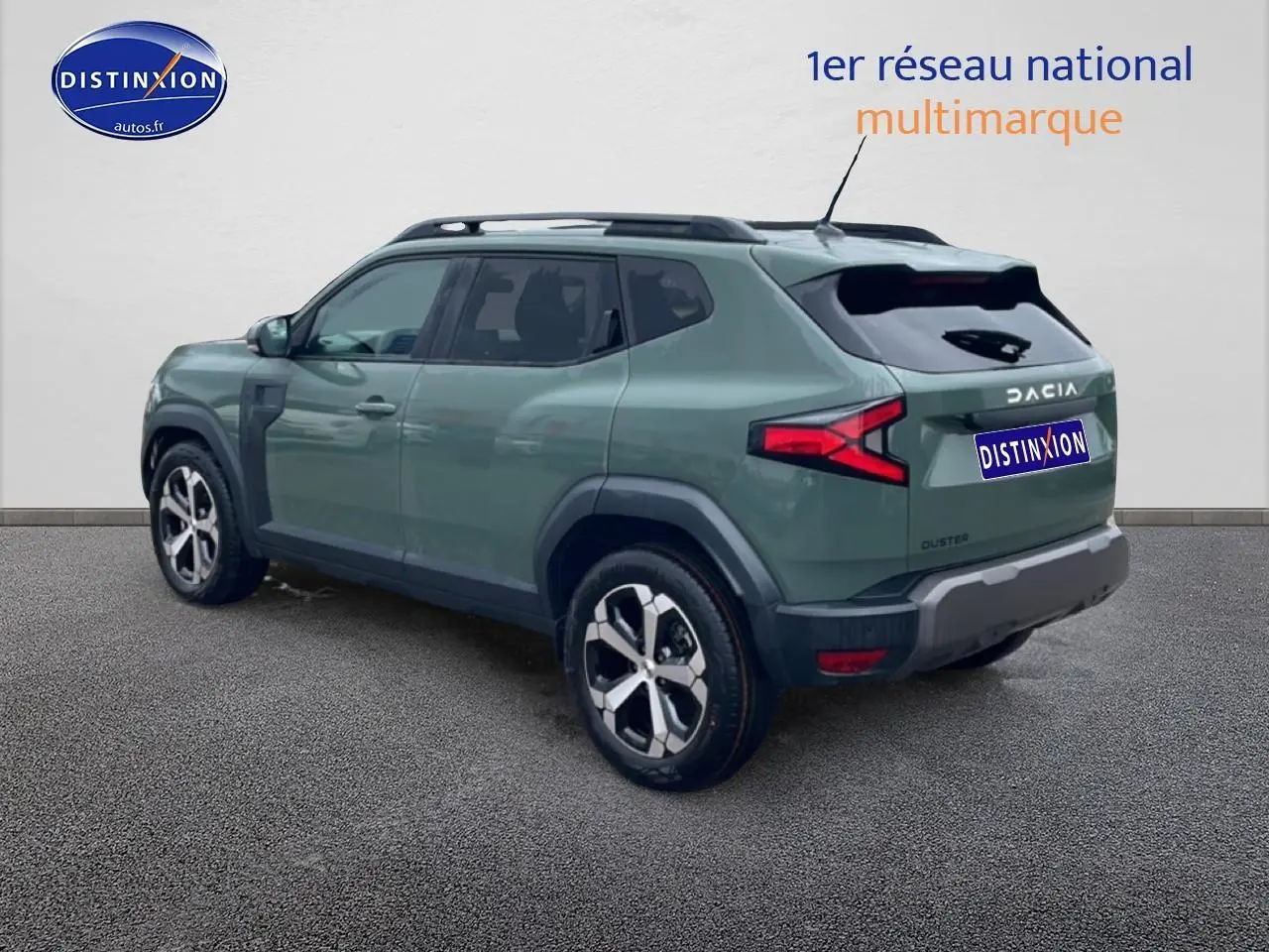 Vue 3/4 arrière droite d'un Dacia Duster vert kaki avec barres de toit et jantes alu distinctives.