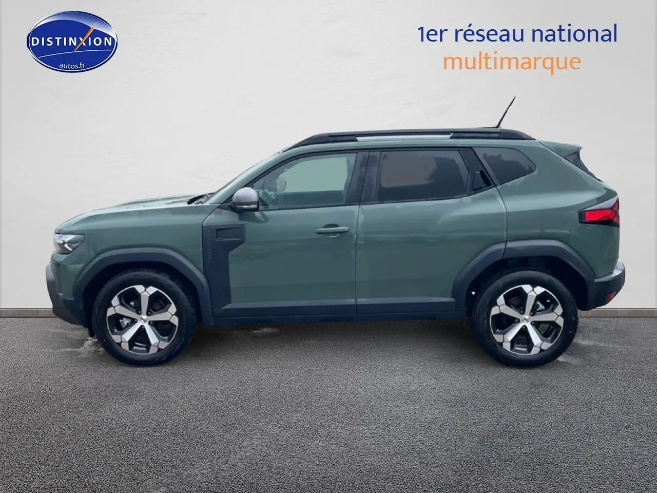 Profil droit du Dacia Duster 2026 vert kaki avec jantes alliage et barres de toit noires.