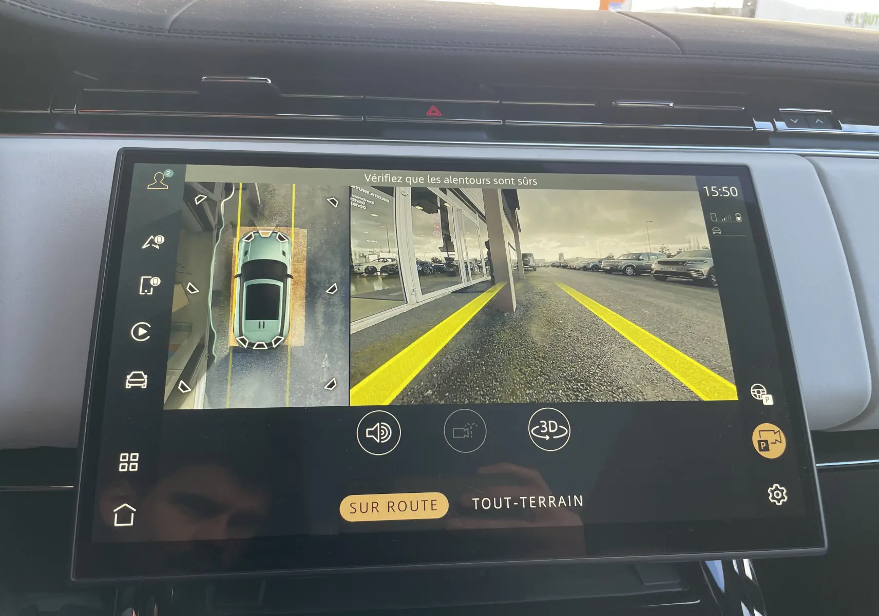 Écran central montrant la caméra 360° du Range Rover Sport P440 HSE R-Dynamic rouge, vue arrière avec lignes de guidage jaunes.