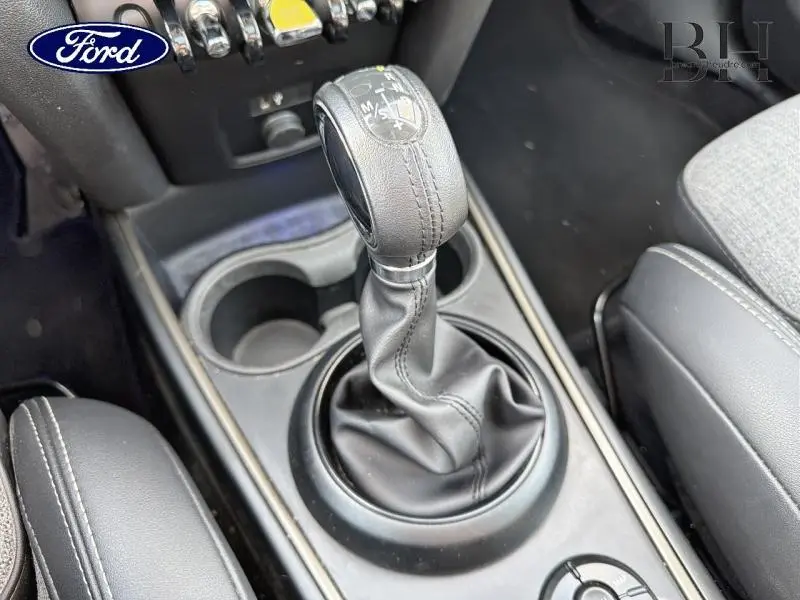 Le levier de vitesse automatique en cuir noir du MINI Countryman Cooper SE, vu en gros plan côté console centrale.