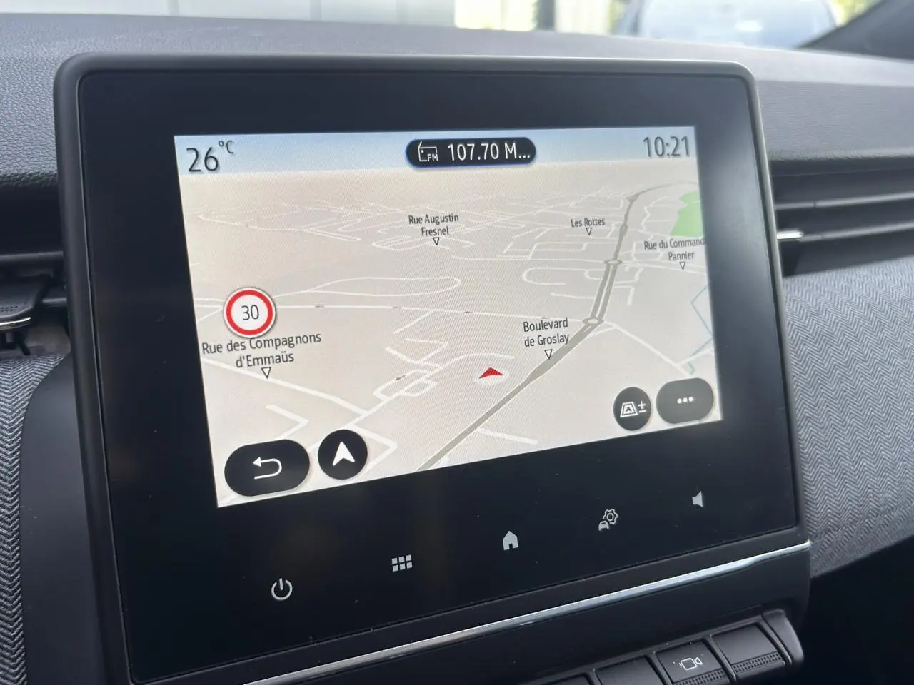 Écran tactile central du tableau de bord de la Renault Clio 2025 affichant la navigation GPS et la température extérieure.