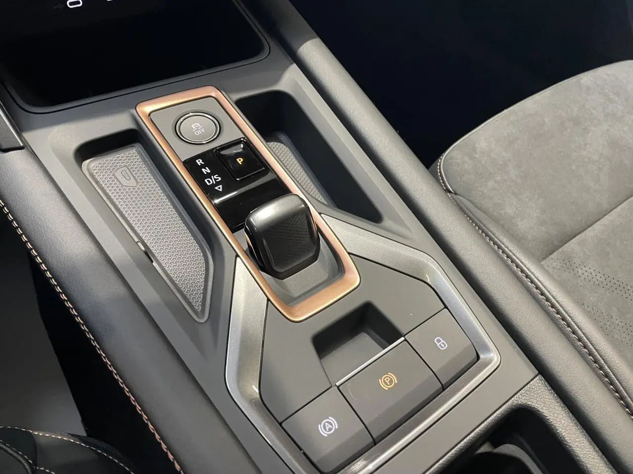 Gros plan sur la console centrale de la CUPRA Leon 2.0 TDI noire, avec levier de vitesse DSG et surpiqûres cuivrées.