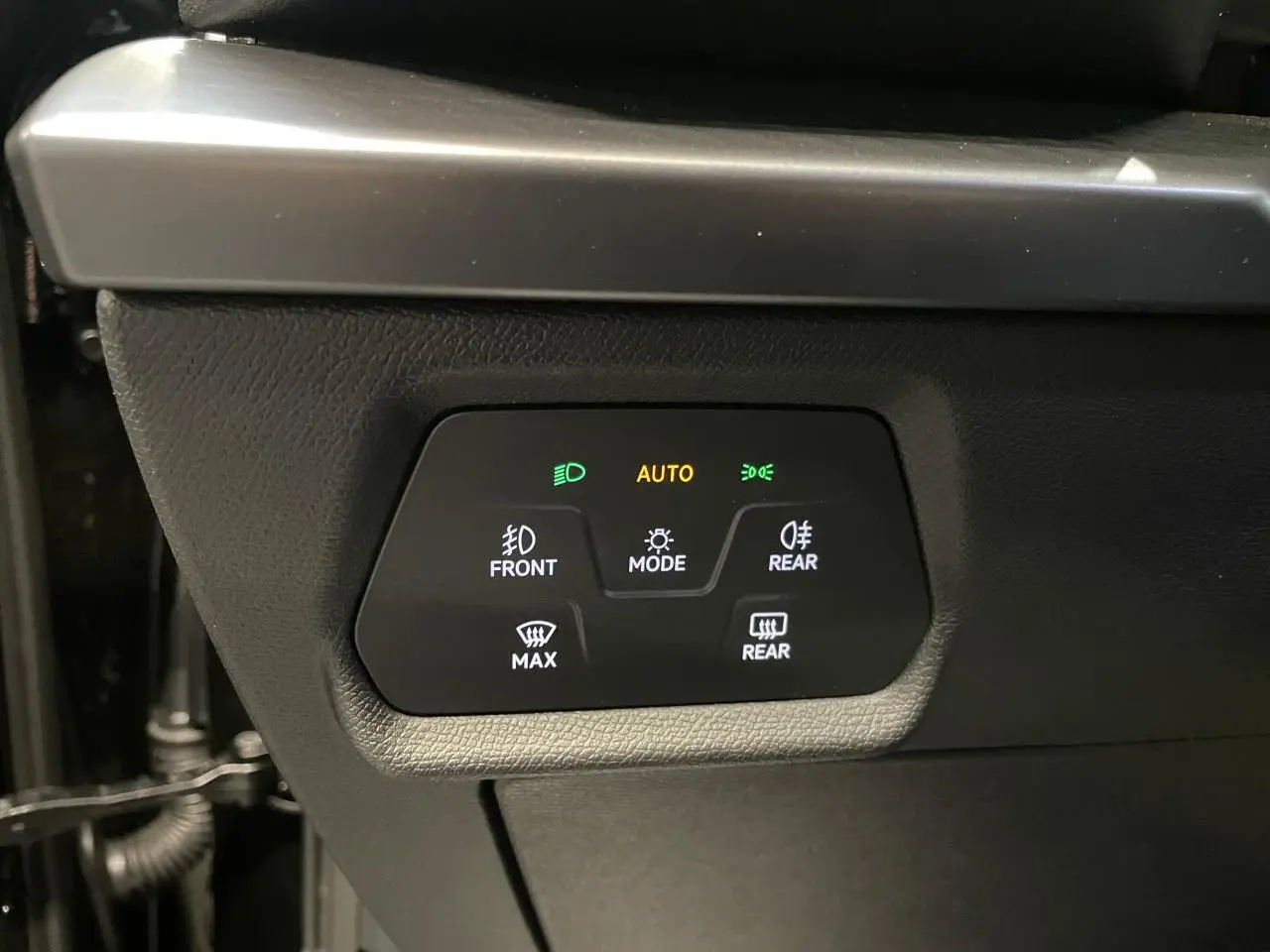 Panneau de commandes d’éclairage intérieur noir avec indicateurs verts et orange dans une CUPRA Leon 2.0 TDI noire.