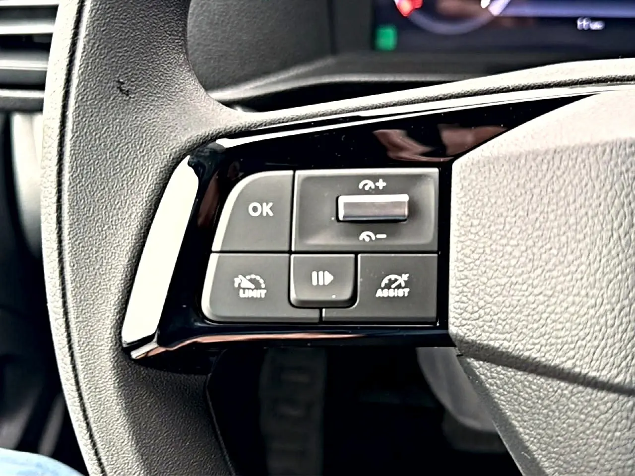 Gros plan sur les commandes noires au volant du Fiat Scudo Combi gris titane, mettant en valeur les boutons d'assistance et limiteur.