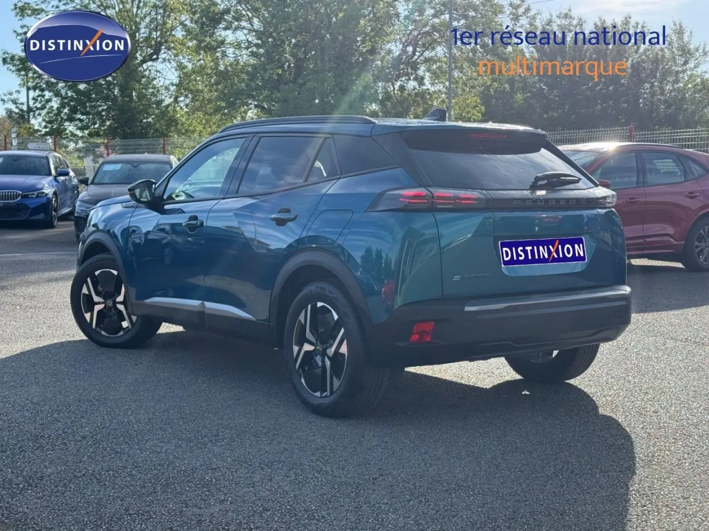 Vue 3/4 arrière droite du Peugeot e-2008 2025 en Bleu Obsession, avec jantes alu et feux arrière LED distinctifs.