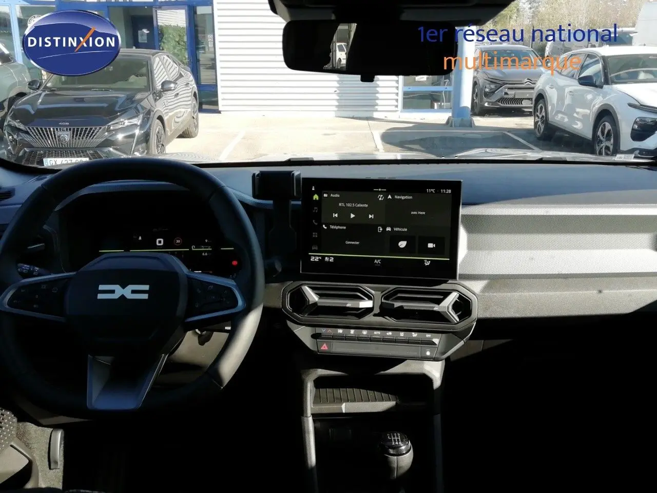Vue intérieure du tableau de bord du Dacia Duster 2026, avec écran tactile central et volant multifonction noir.