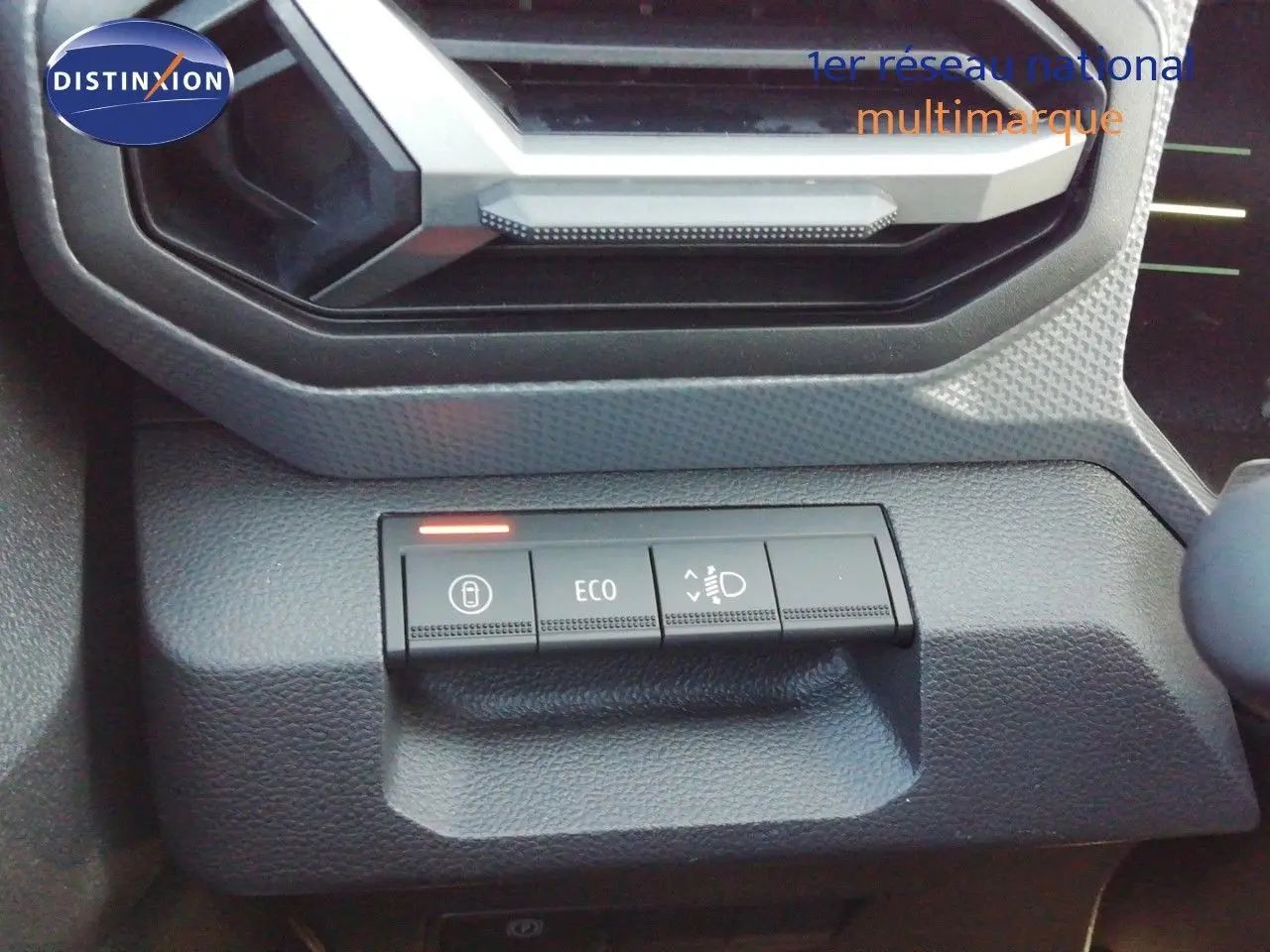 Boutons de commande du tableau de bord du Dacia Duster 2026, avec fonction ECO et réglage des phares, finition gris noir.