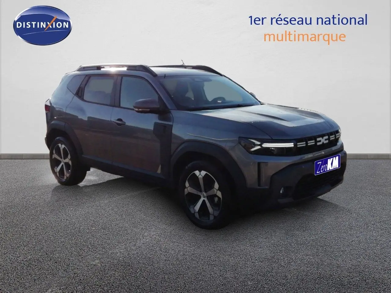 SUV Dacia Duster gris schiste métal en 3/4 avant droit, avec jantes bi-ton et calandre moderne à LED.