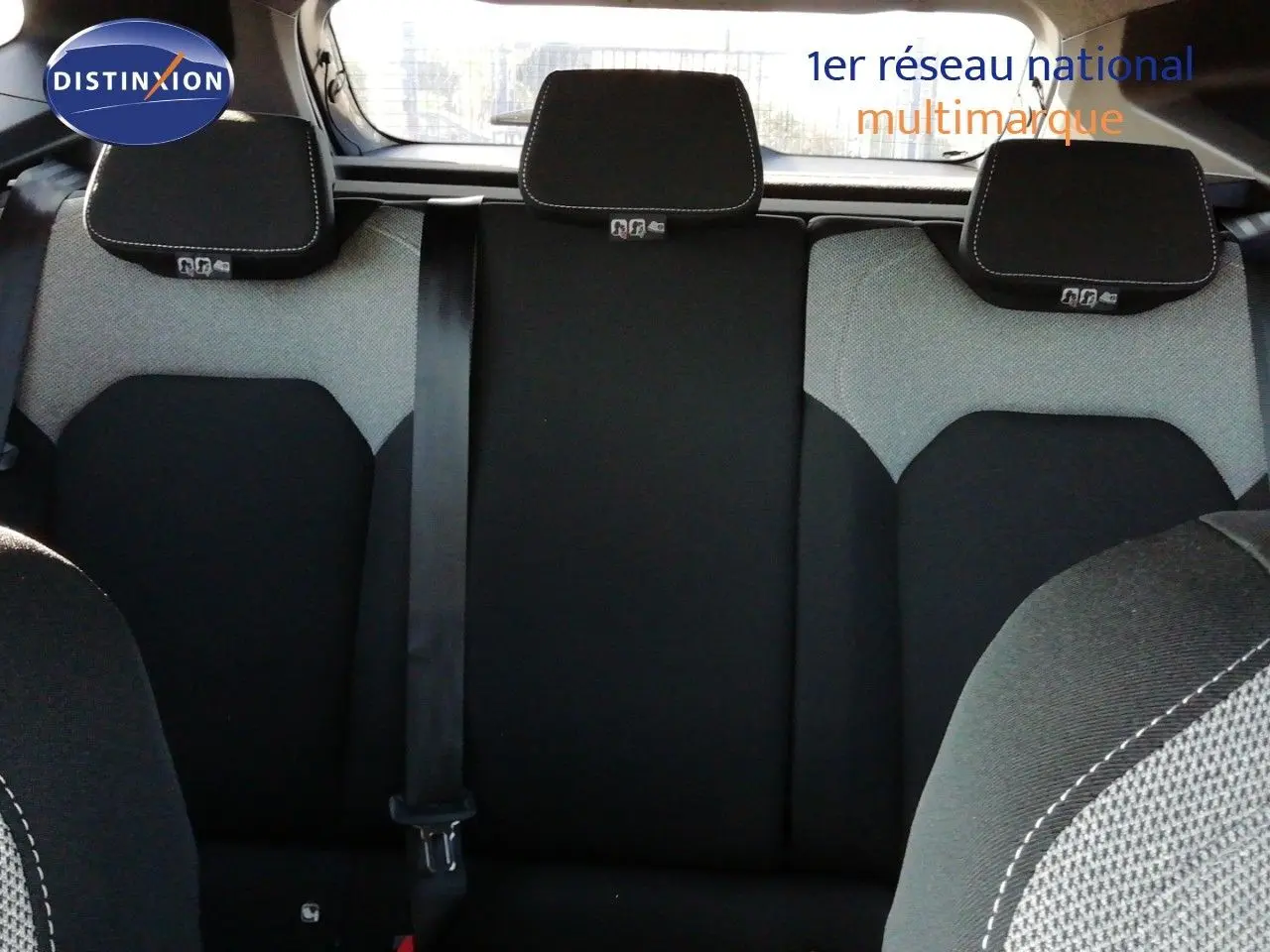 Vue intérieure des sièges arrière du Dacia Duster 2026, tissu bicolore gris et noir avec appuie-têtes intégrés.