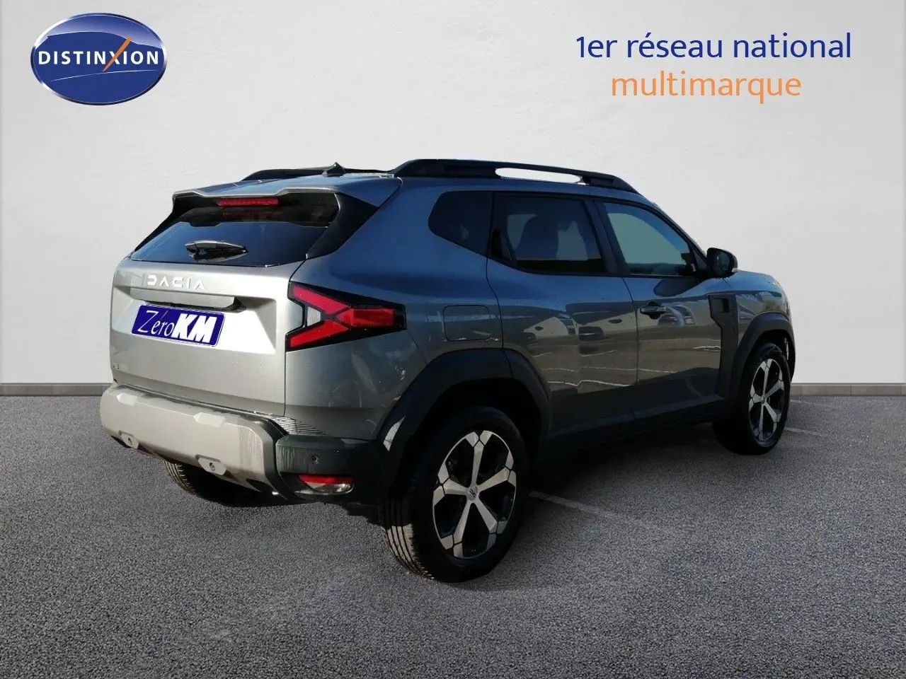 Vue 3/4 arrière droite du Dacia Duster gris schiste métal avec jantes bi-ton et feux arrière LED distinctifs.