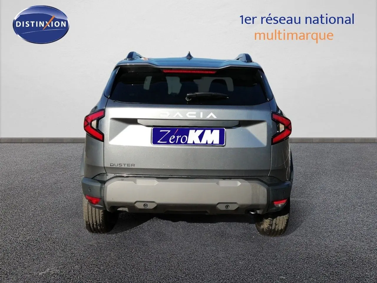Vue arrière d’un Dacia Duster gris schiste métal 2026 avec feux LED et logo DACIA visible.