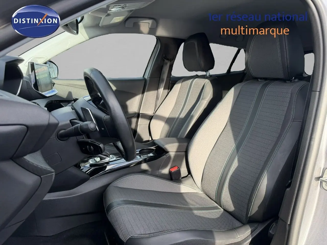 Vue intérieure côté conducteur du Peugeot 2008 gris Artense, mettant en valeur les sièges en tissu et cuir noir.