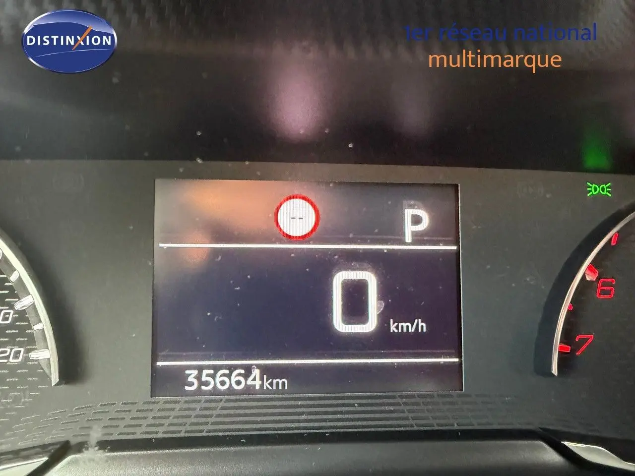 Tableau de bord numérique d'une Peugeot 2008 gris Artense, affichant 0 km/h et 35 664 km au compteur.