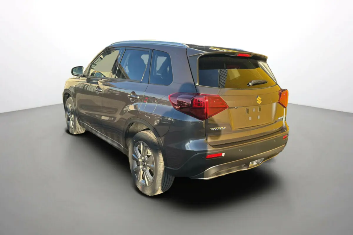 Suzuki Vitara 2025 gris silky silver en vue 3/4 arrière droit, avec feux arrière et jantes alliage visibles.