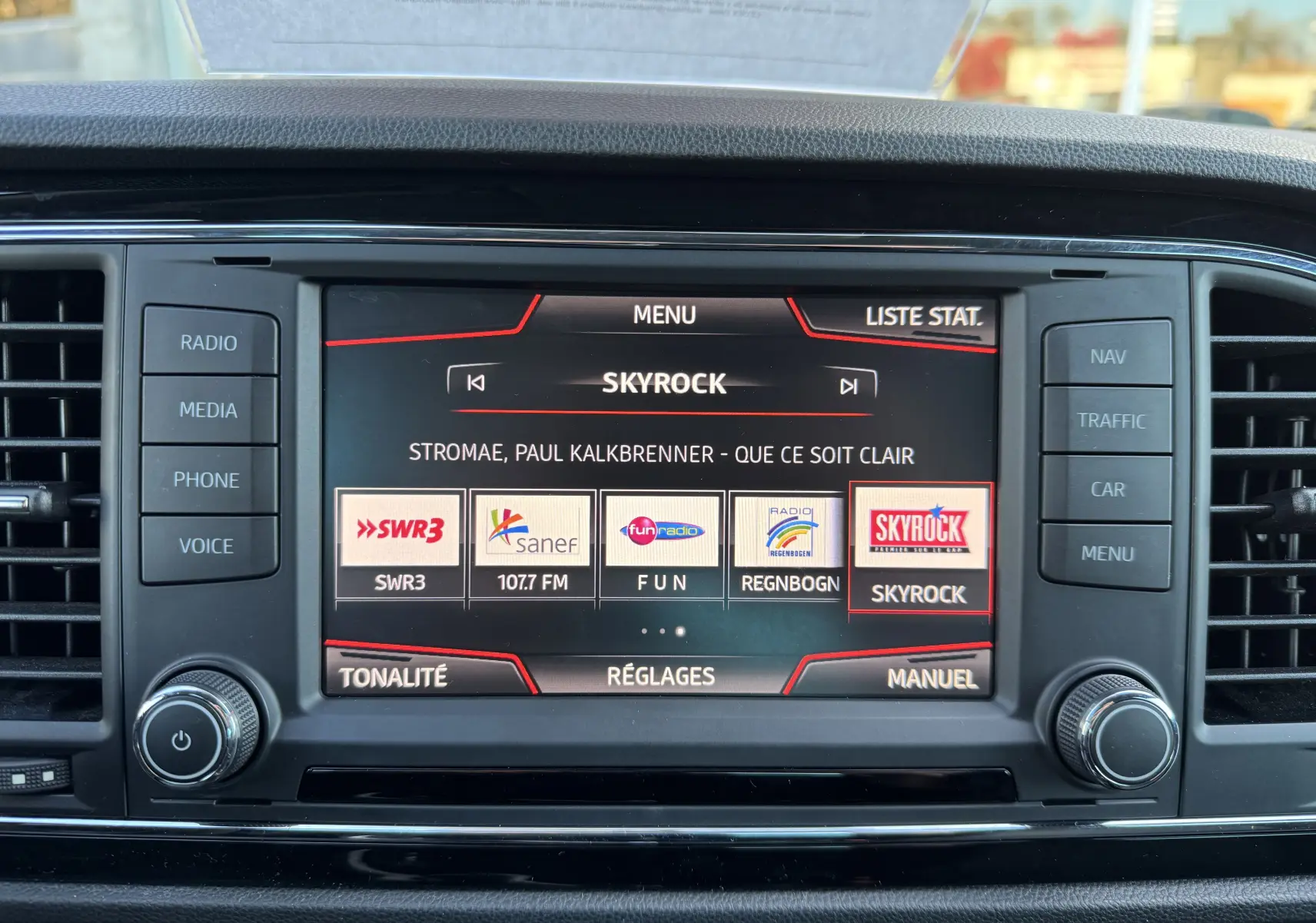 Écran central tactile de la SEAT LEON gris 2016 affichant la radio Skyrock avec les options média et navigation visibles.
