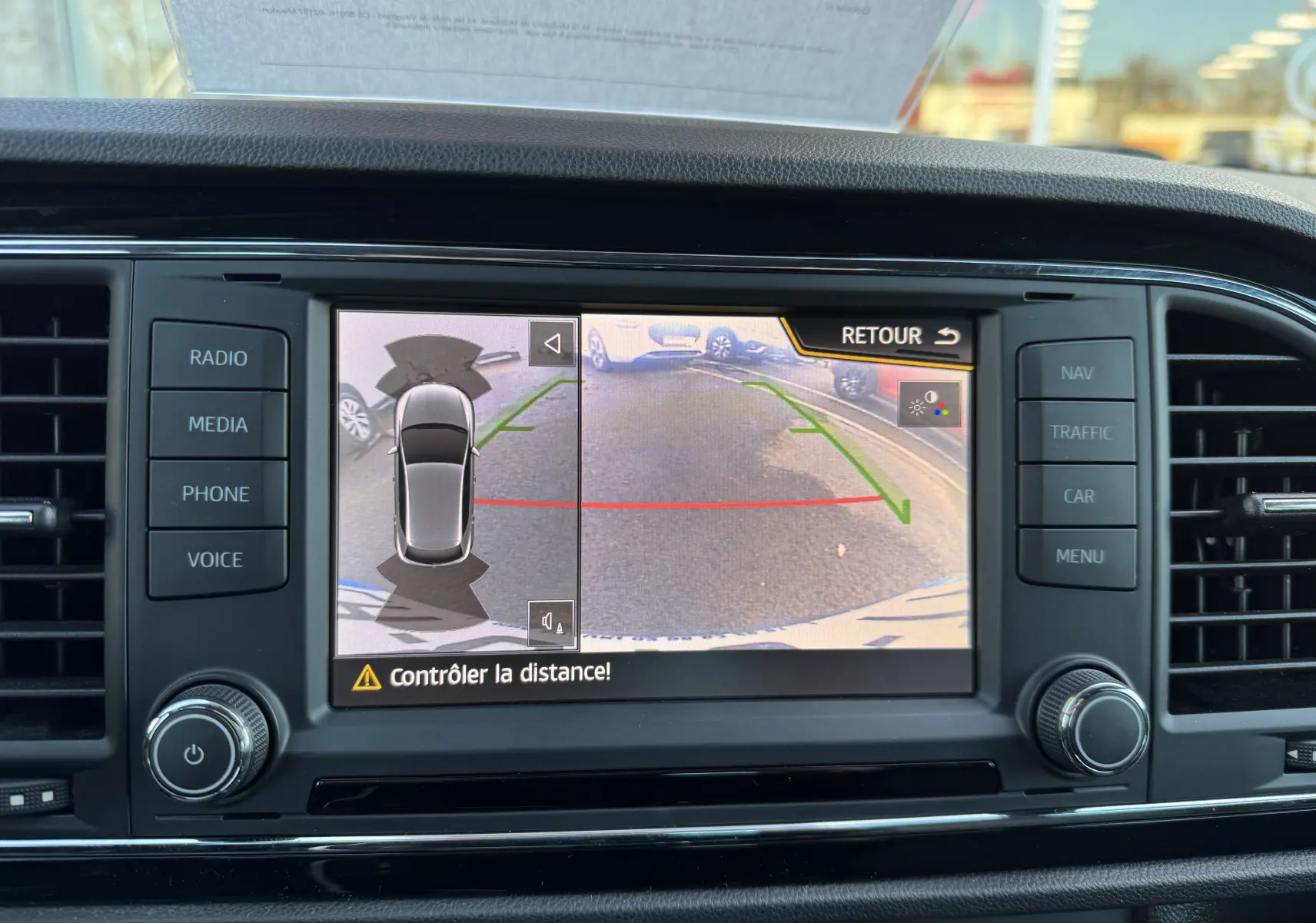 Écran central de la SEAT LEON gris 2016 montrant la caméra de recul avec guidage de trajectoire verte et rouge.