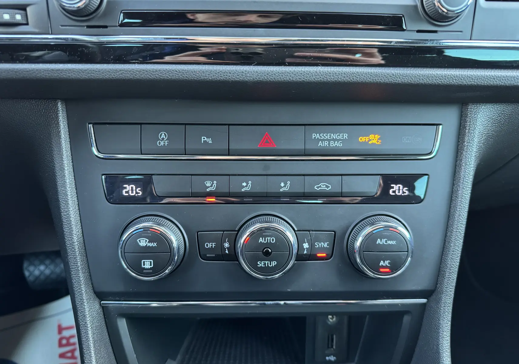 Détail du tableau de bord de la SEAT LEON gris 2016 montrant les commandes de climatisation et les voyants allumés.