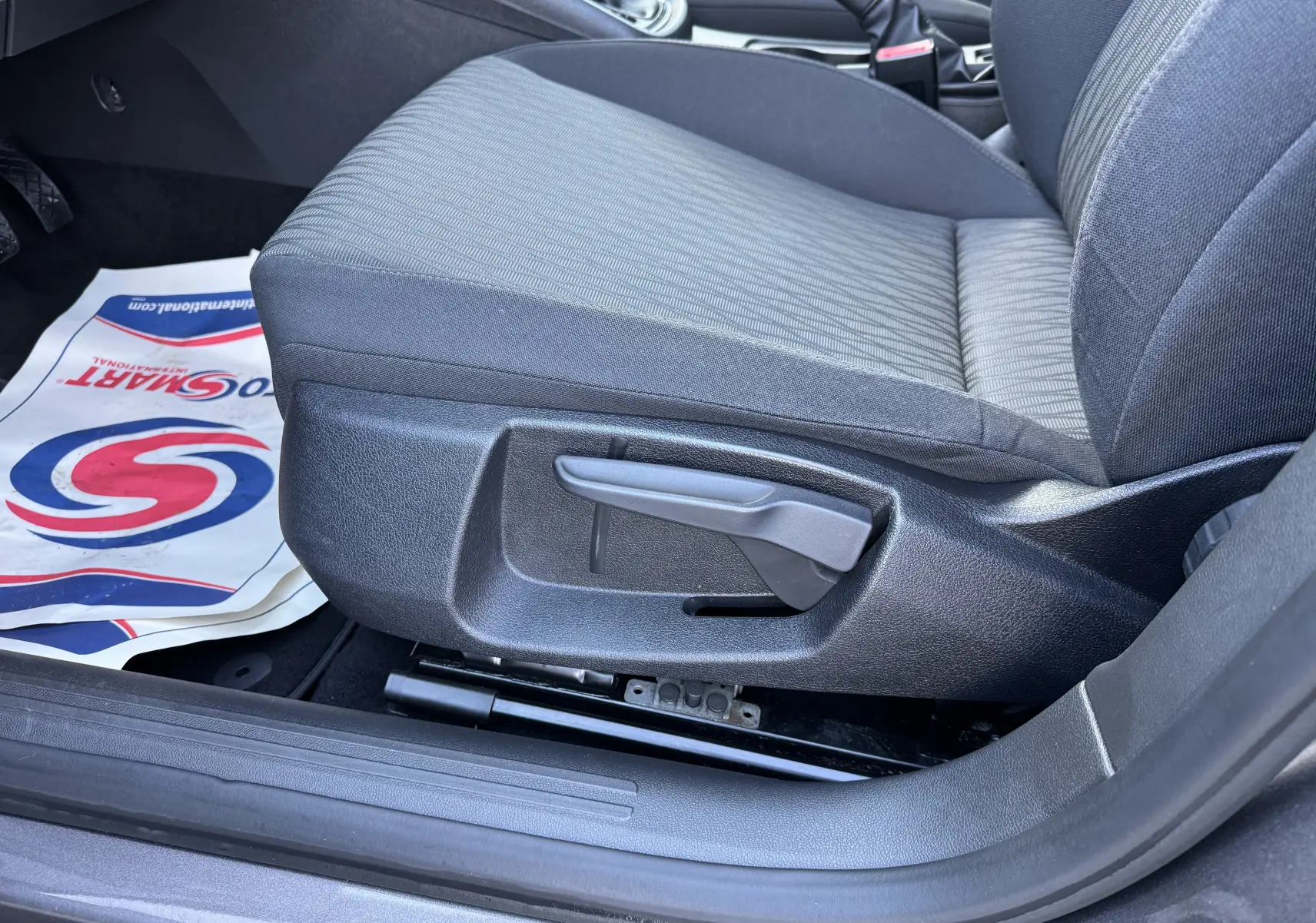 Gros plan sur le siège avant droit en tissu gris du SEAT LEON 2016, montrant la commande manuelle d'ajustement.